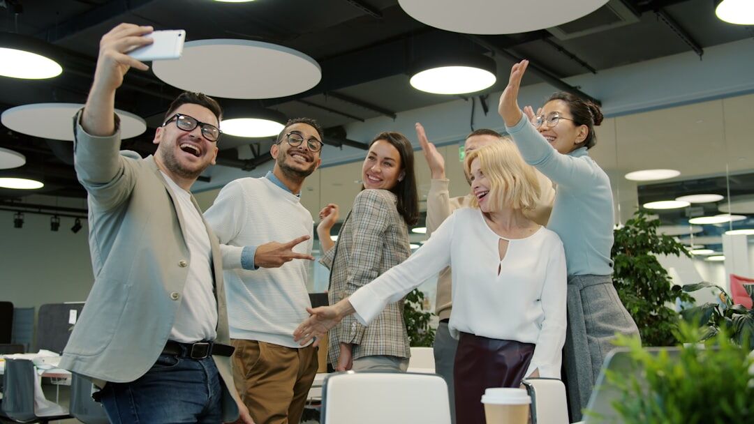 Diverse team laughing together during an indoor team building session in a modern Belgian office