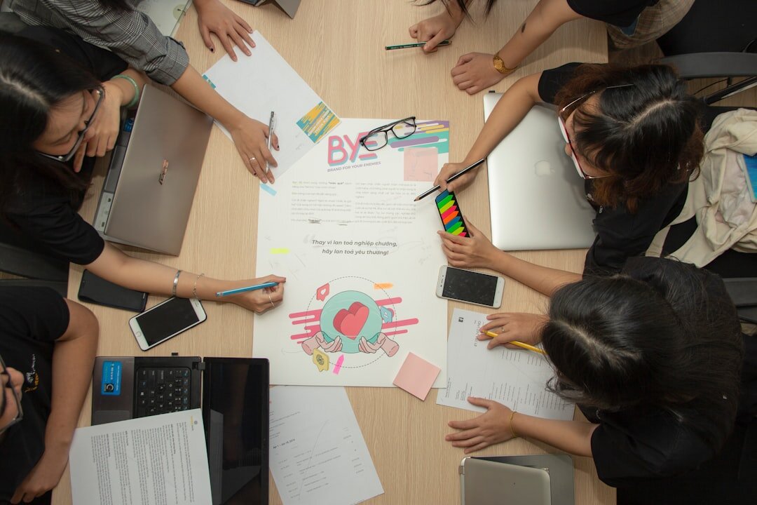 Colleagues brainstorming with sticky notes on a glass wall