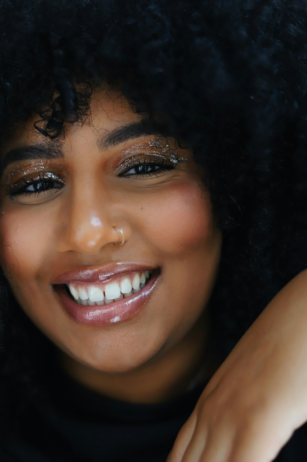 Studio portrait of a smiling North African woman with curly hair